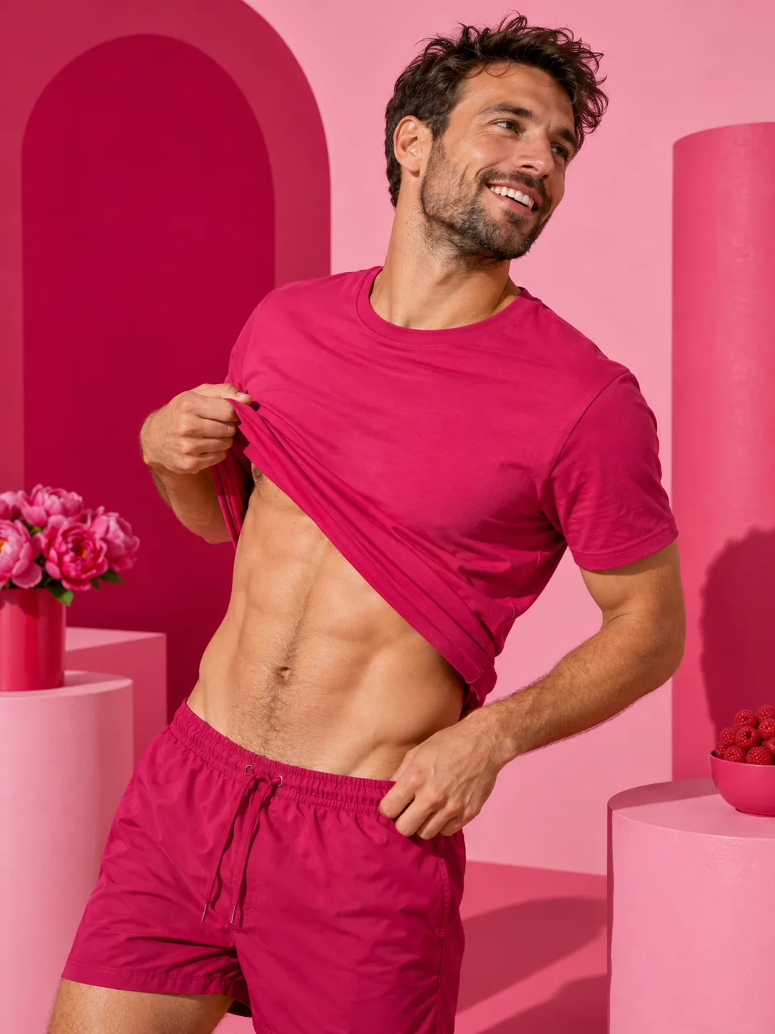 Homme sportif relevant son t-shirt fuchsia sur un ventre tonique